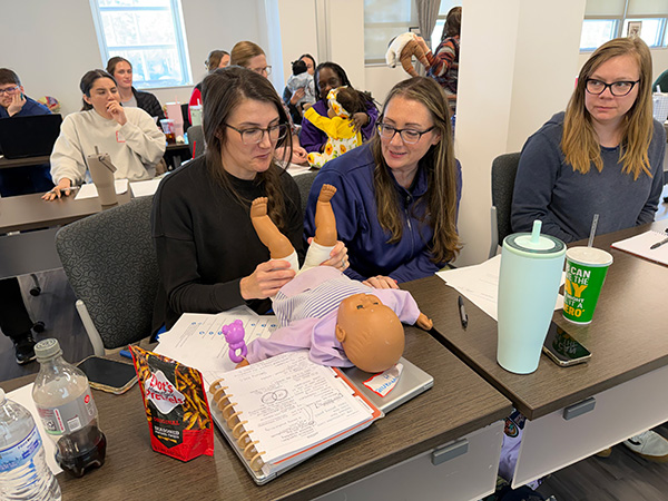 3 MGA Occupational Therapy Students working on baby dummy